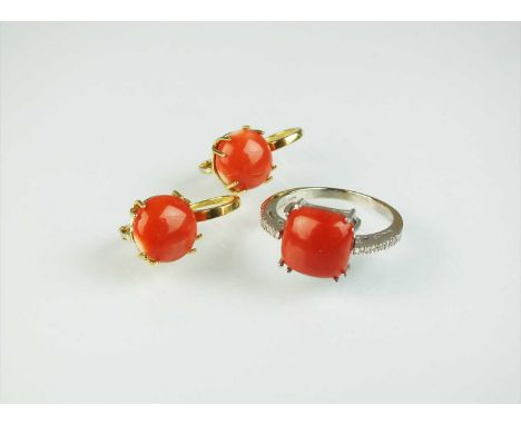 A coral and diamond ring, designed as a square cushion coral cabochon, claw set to graduated diamond shoulders, the white met