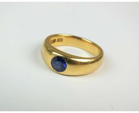 A single stone untested sapphire ring, mounted within tapering yellow metal shank, stamped '18', ring size M 1/2, weight appr