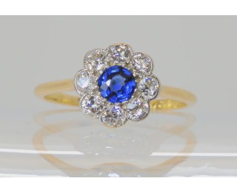 A vintage sapphire and diamond flower ring, the shank stamped '18' set with estimated approx 0.40cts of old cut diamonds, fin