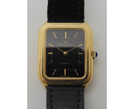 An 18ct gold case ladies Baume &amp; Mercier watch, with a black dial, gold coloured baton numerals and hands, with a gem set