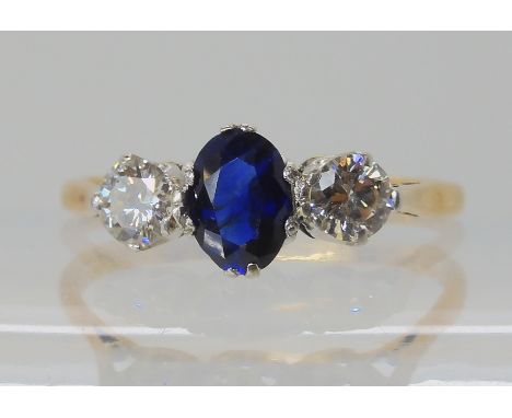 An 18ct diamond and sapphire three stone ring, dimensions of the sapphire 7mm x 5mm, diamonds estimated approx 0.25cts each, 