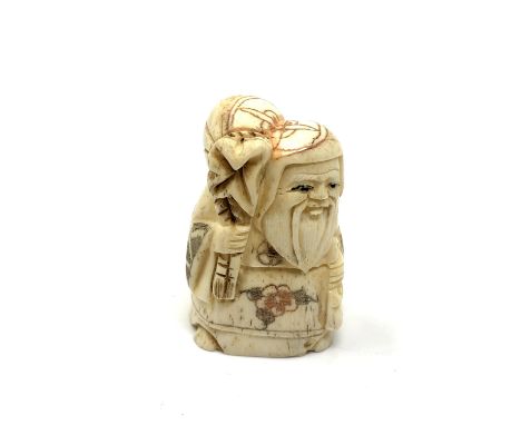 A carved bone netsuke - Bearded man with sack