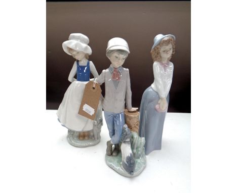 A Nao figure of a boy leaning on a stump with puppy, together with two further Nao figures of girls. 
