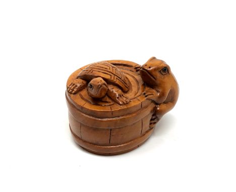 A carved hardwood netsuke - Turtle and frog in barrel
