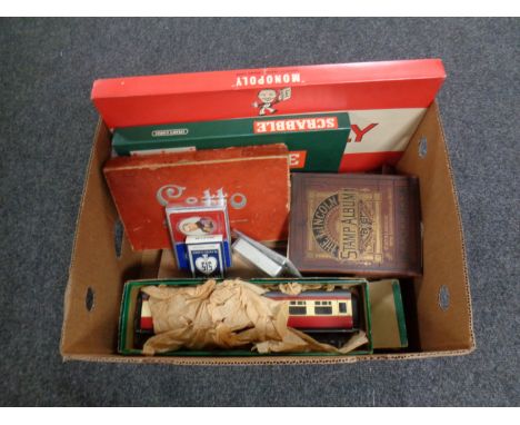 A box containing vintage and later games, a large scale tin plate train carriage, stamp album, playing cards etc 