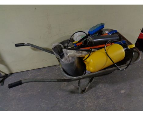 A wheelbarrow containing garden sprayers, tools etc 