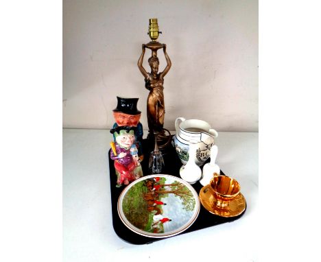 A tray of miscellany to include figural table lamp, character jugs, hand bells, antique transfer printed jug etc 