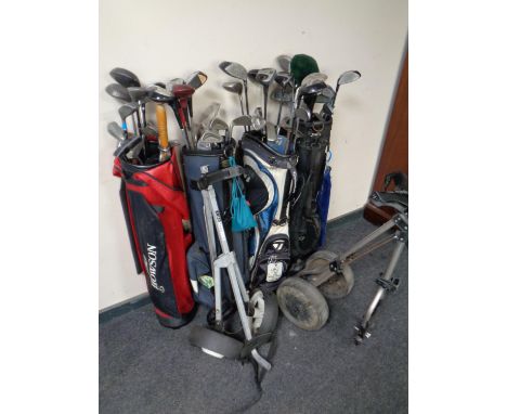 Four golf bags containing assorted irons and drivers to include Donnay, Howson, Hippo etc, together with two folding golf tro