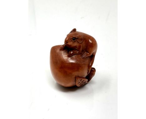 A carved hardwood netsuke - Rat on peach
