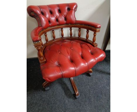 A red button leather captain's swivel desk chair 