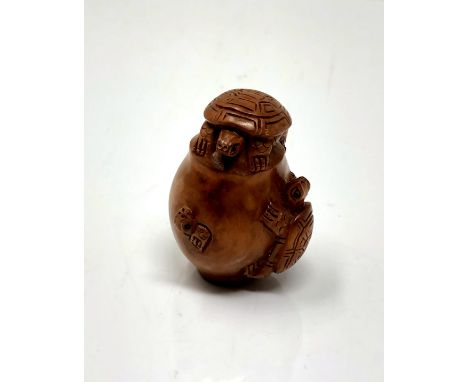 A carved hardwood netsuke - Turtle family in a pot