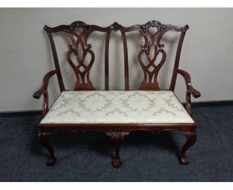 A reproduction Chippendale style two seater settee on claw and ball feet  