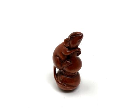 A carved hardwood netsuke - Rat climbing a spike