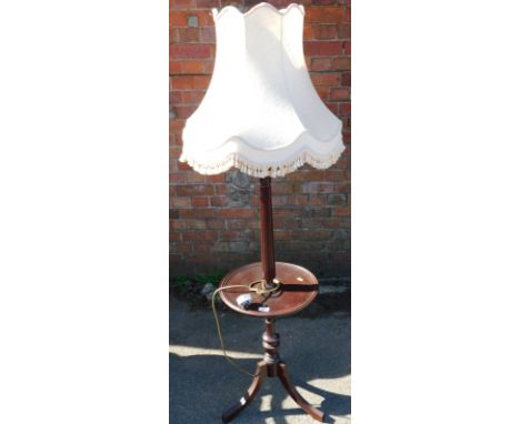 A mahogany standard lamp, with wine table base and shade.