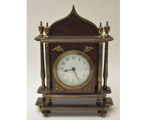 An early 20th Century lacquered brass and mahogany mantel clock, the w hite enamel arabic dial within architectural case fitt