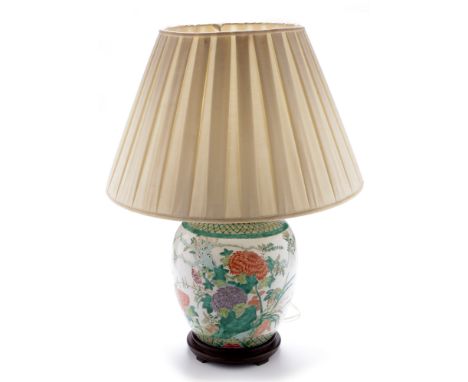 A Chinese Famille Rose jar and cover, converted to a table lamp base , decorated with flower sprays within green diaper borde