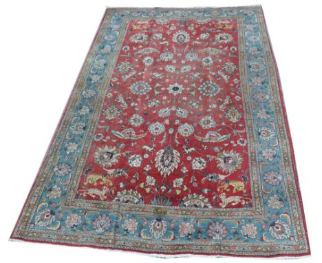 Tabriz carpet, decorated with bold floral scrolls surrounded by big-cats and antelopes, 234 x 360cms.