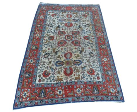 Qum carpet, with floral scrolls amongst wolves and deer on cream ground, 211 x 328cms.