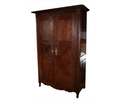 An 18th Century French Provincial oak armoire, the moulded cornice above a pair of long cupboard doors enclosing hanging spac