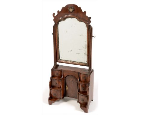 A George III mahogany swing mirror, the fret carved top and moulded edges enclosing the mirror-plate, flanked by fluted suppo