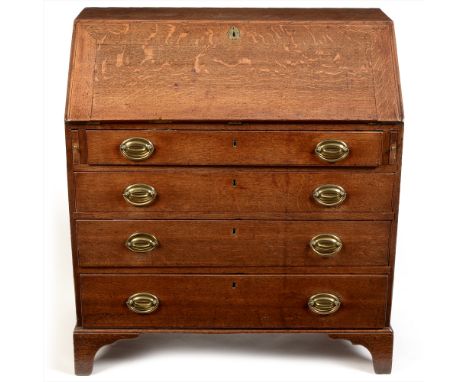 A George III oak bureau , the fall-front enclosing a fitted interior, above an arrangement of two short and three long gradua