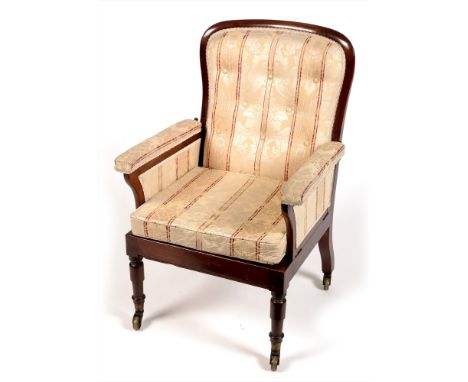 A Victorian mahogany framed armchair, the spoon-back enclosing a button back and cushion seat with upholstered drop-down arms