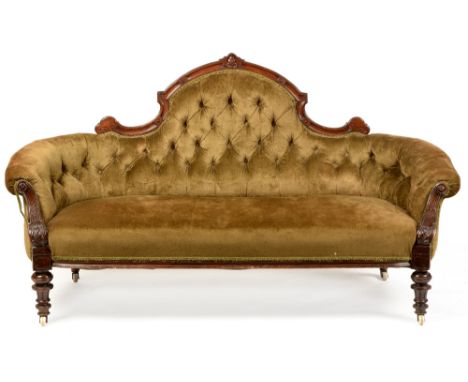 A mid Victorian walnut framed sofa , the arched top rail surmounted by an enclosed palmette, above a green velvet upholstered