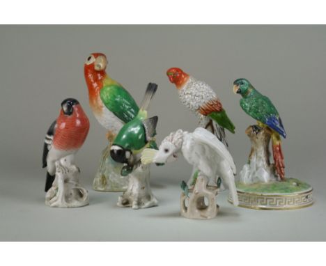 A collection of Continental porcelain figures, late 19th/early-mid 20th century, including three parrots seated upon naturali