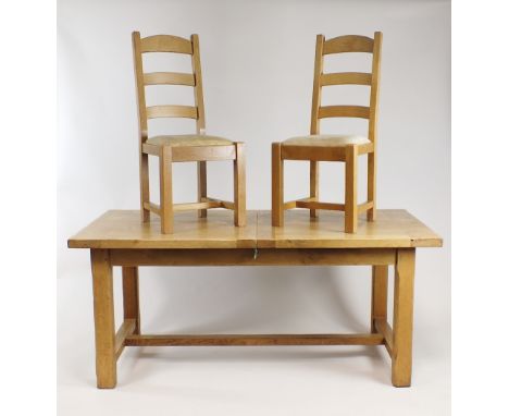 An oak dining table and six (5+1) ladder back chairs en suite, the table with mitred sliding extending top on four canted blo