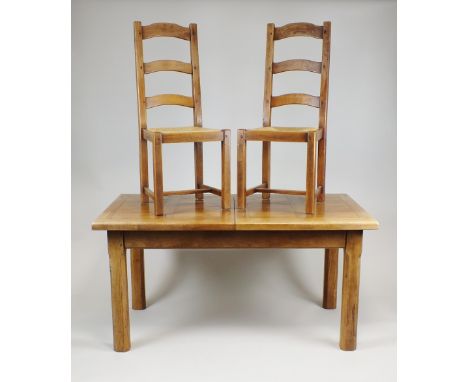 An oak dining table and six chairs en suite the dining table with rectangular mitred pull out extending top with two extra le