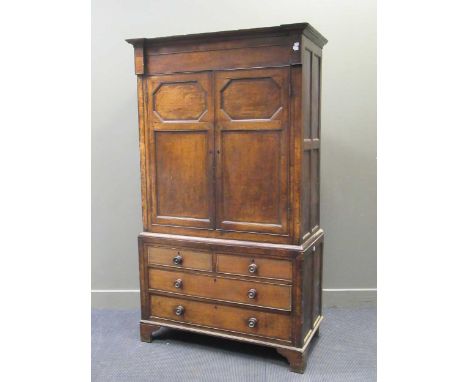 A late 18th / early 19th century oak and mahogany linen press, the ipper section with moulded doors enclosing shelves, the bo
