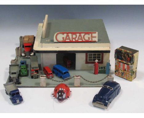 A model toy garage, probably 1950s, with various Dinky, Minic and other model trucks and cars