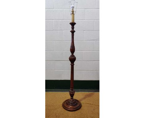 A 20th century carved wood standard lamp, the fluted and knopped column on a stepped circular base with shade, 133cm high (no