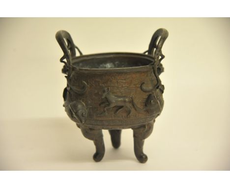 A Chinese twin handled bronze pot cast with raised naturalistic decoration (no lid) height: 21cm approximately