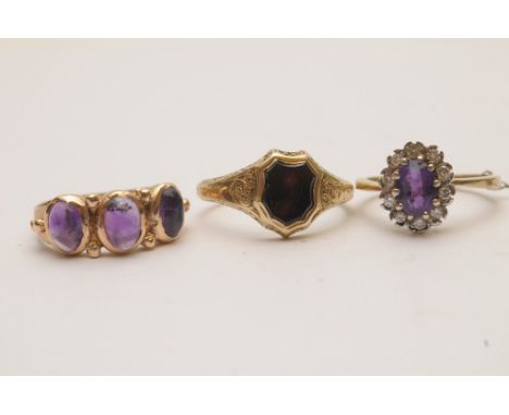 Three unmarked  gold rings compriosing a 19th century gold ring set with blank seal of shield shape, an amethyst and diamond 
