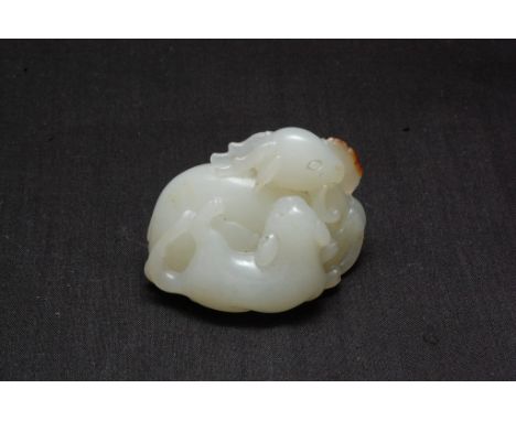 A small Chinese jade carving of two entwined animals, possibly 19th century or older, unsigned