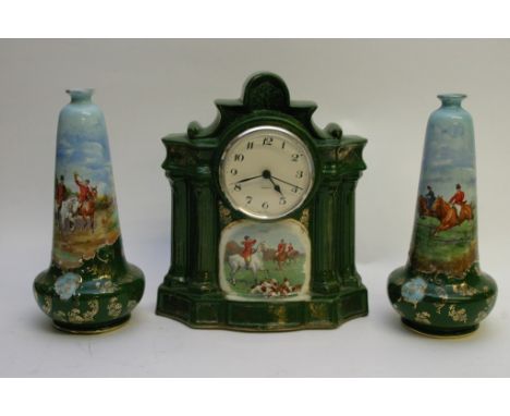 A ceramic clock garniture decorated with hunting scenes