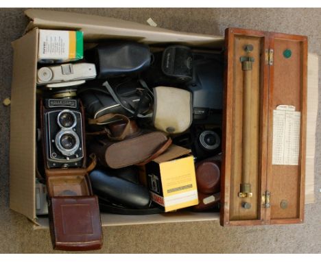 A box containing a collection of assorted vintage cameras and a cased rolling rule