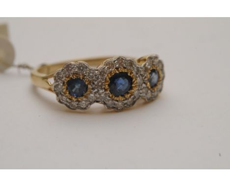 A ladies 18ct yellow gold ring set with three round cut blue sapphires each with diamond surround