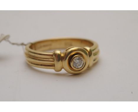 A ladies 18ct yellow gold ring of modern design bezel set with a brilliant cut diamond solitaire