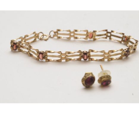 A gold garnet set gate bracelet and a pair of red stone set earrings 