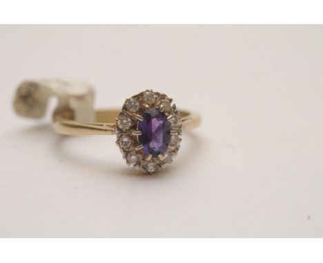 A ladies 9ct gold ring set with central amethyst with diamond surround