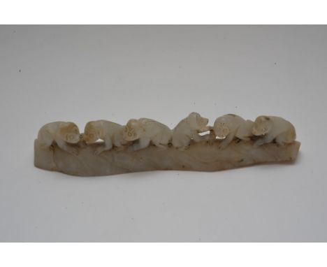 A Chinese jade carving in the form of six monkeys along a naturalistic plinth base. Length: 16cm approximately