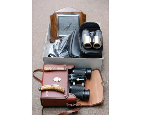 A box containing two antler handled folding knives, a barometer, three pairs of binoculars 