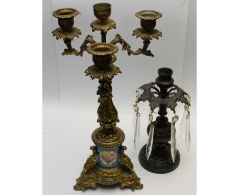 A small antique bronze candlestick with glass lustres and a gilt metal candlestick with floral painted porcelain panel