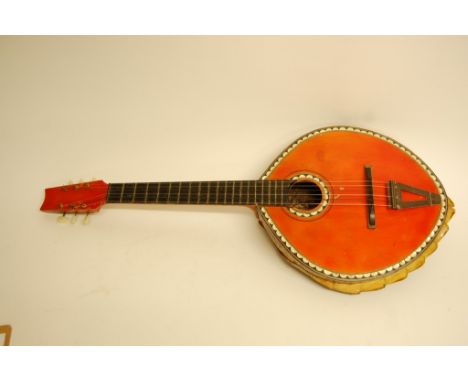 A rare and unusual oval vintage guitar, the sides covered in tortoiseshell, the back a complete turtle shell, the front edged