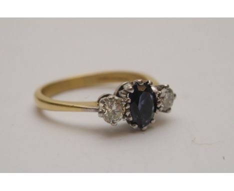 A ladies 18ct yellow gold ring set with a central oval cut amethyst flanked by brilliant cut diamonds