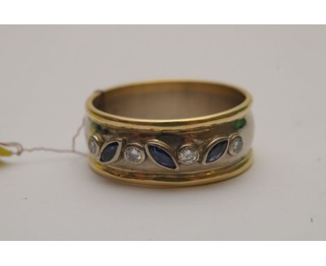 A ladies 18ct dual tone gold ring bezel set with raised round cut diamonds and marquise cut blue sapphires