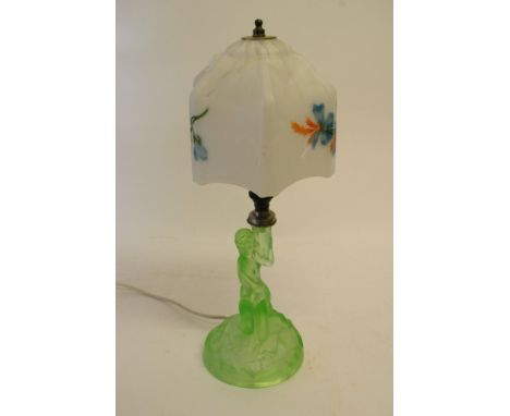 An Art-Deco green glass lamp-stand depicting a crouching lady supporting a glass lamp-shade with floral design