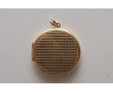 A 9ct gold locket of circular shape with engine turned decoration